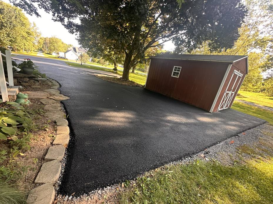 The same driveway paved with new asphalt up to the red shed