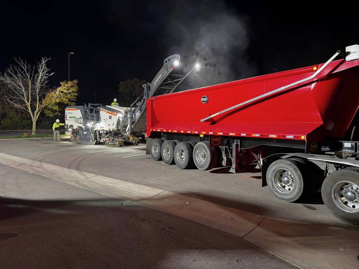 Milling machine and dump trailer working a parking lot at night